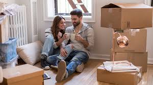 A happy couple smiling with packed boxes